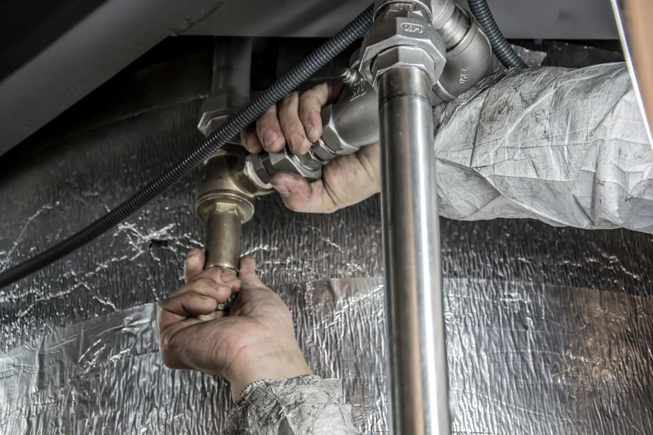 給湯器交換の配管工事をしている作業員の手元